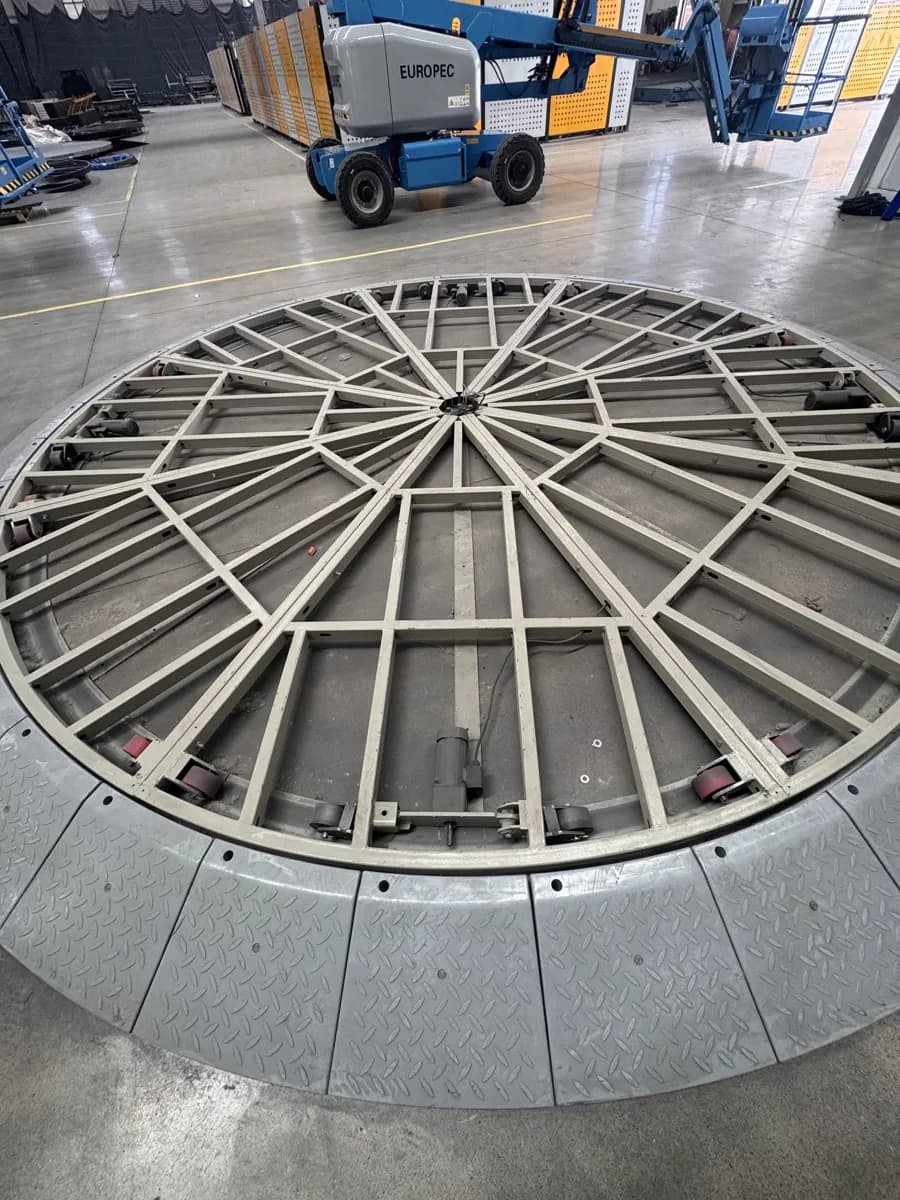Uncovered circular turntable frame and radial members in a workshop
