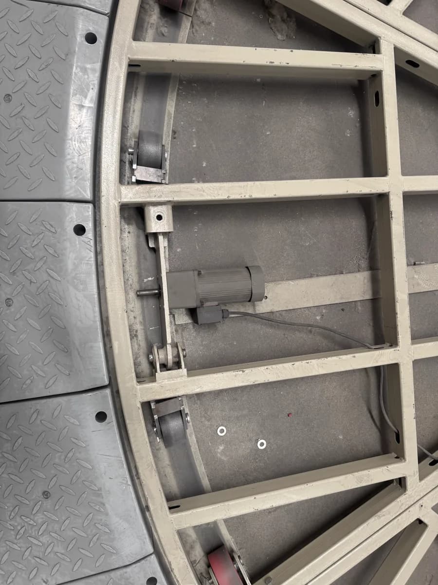 Motor and wheel components beside the exposed turntable frame and deck edge